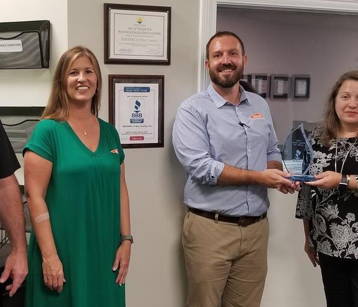 3 SERVPRO employees receiving an award at the SERVPRO of Bay County Office