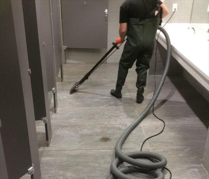 Man extracting water in a commercial bathroom on Panama City Beach, Florida