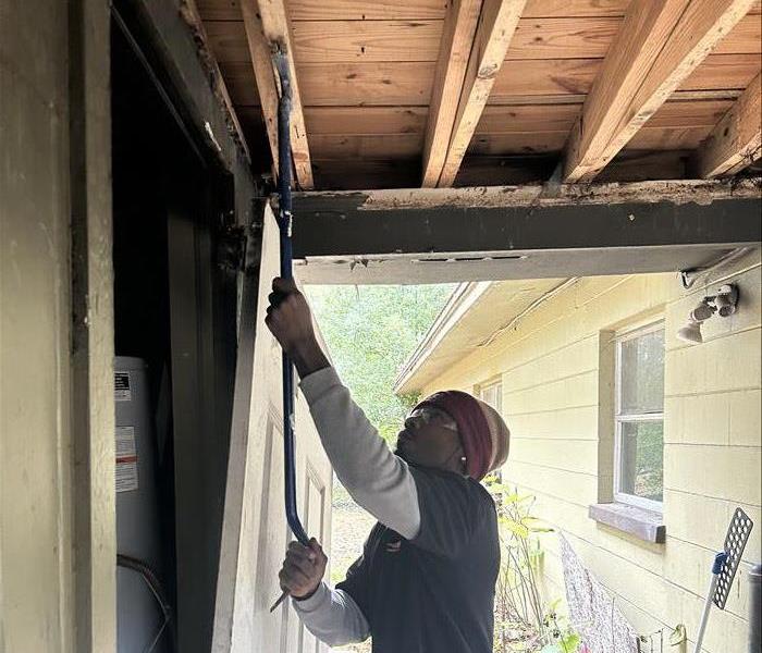 SERVPRO Technician inspecting wooden joists for water damage