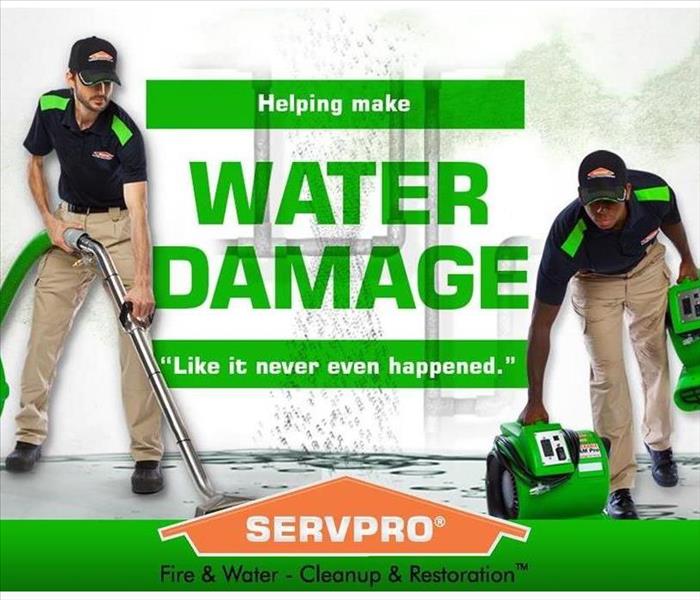 SERVPRO crew cleaning up a water damage with SERVPRO logo