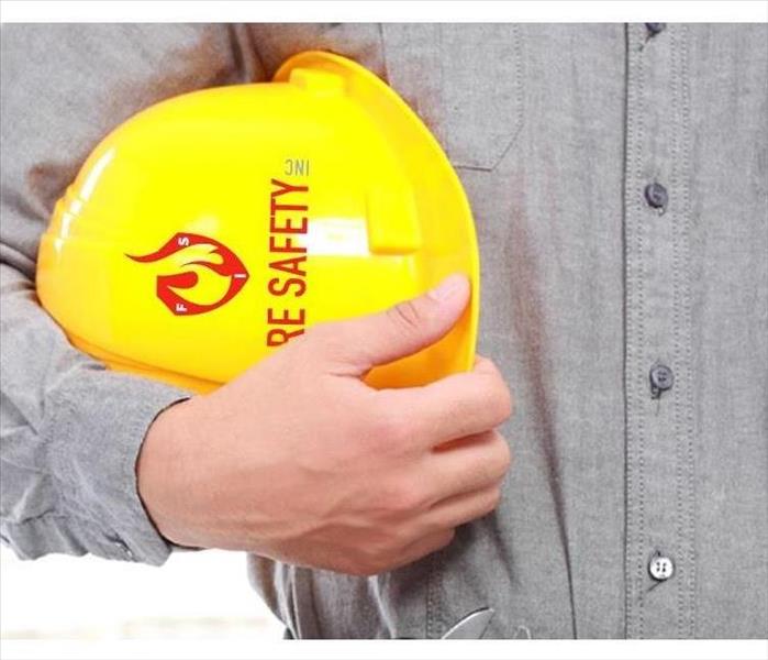 Man holding a hard hat that says fire safety